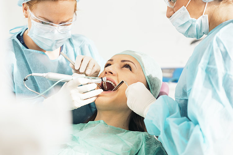 Clínica Dental Andrea Compte, tu Centro Odontológico especializado. Cirugía bucal en Cálig. Dentistas con un paciente durante una intervención dental.