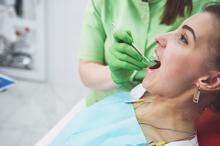 Clínica Dental Andrea Compte, tu Centro Odontológico especializado. Cirugía bucal en Sant Jordi. Dentista curando a una paciente.