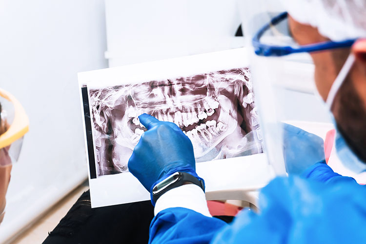 Clínica Dental Andrea Compte, tu Centro Odontológico especializado. Cirugía bucal en Santa Magdalena. Dentista revisando una radiografía oral.
