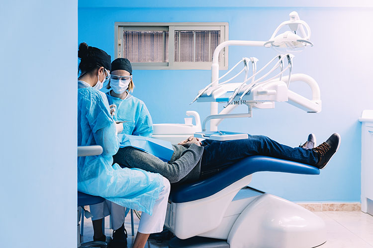 Clínica Dental Andrea Compte, tu Centro Odontológico especializado. Cirugía bucal en Vinaròs. Dentistas realizando una intervención dental a un paciente.