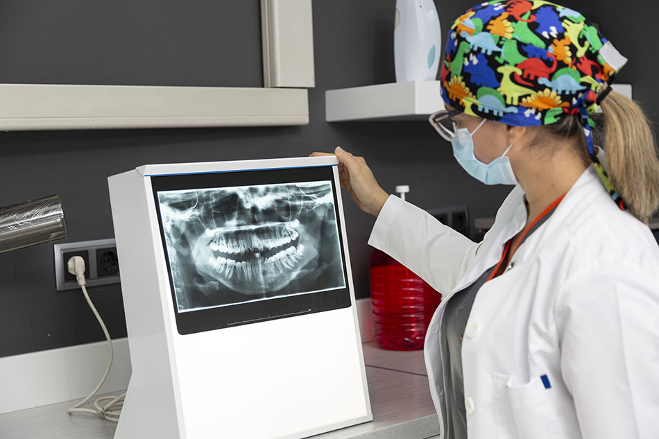 Clínica Dental Andrea Compte, tu Centro Odontológico especializado. Enfermedad periodontal en Cálig. Dentista viendo la radiografía de un paciente.