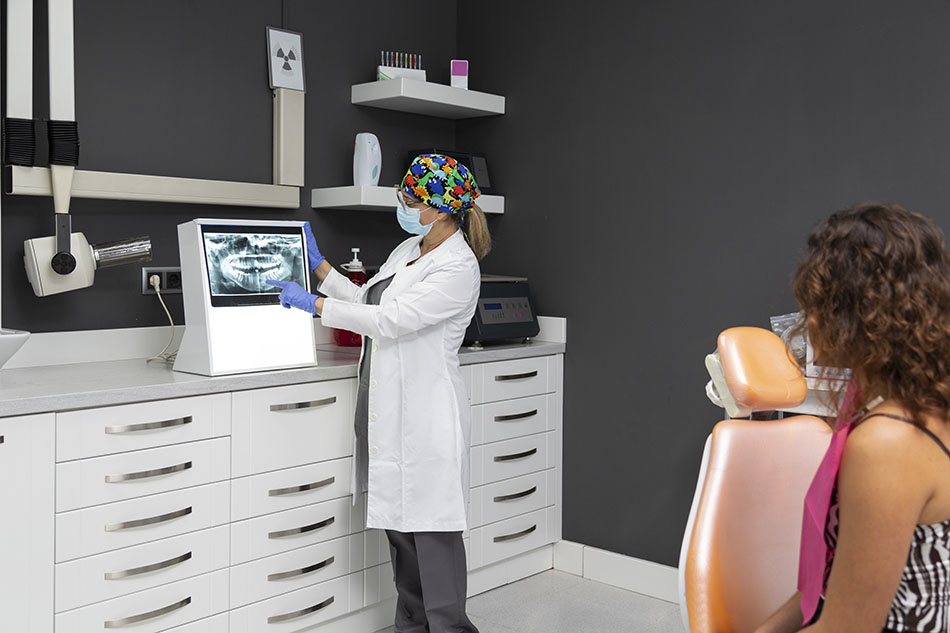 Clínica Dental Andrea Compte, tu Centro Odontológico especializado. Enfermedad periodontal en Peñíscola. Dentista mostrando radiografía dental a su paciente.
