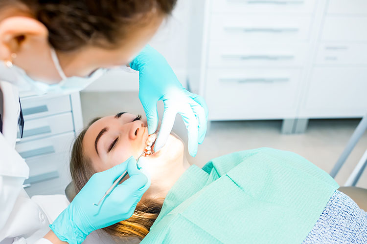 Clínica Dental Andrea Compte, tu Centro Odontológico especializado. Odontología en Alcalá de Xivert. Dentista realizando revisión de los dientes del paciente.