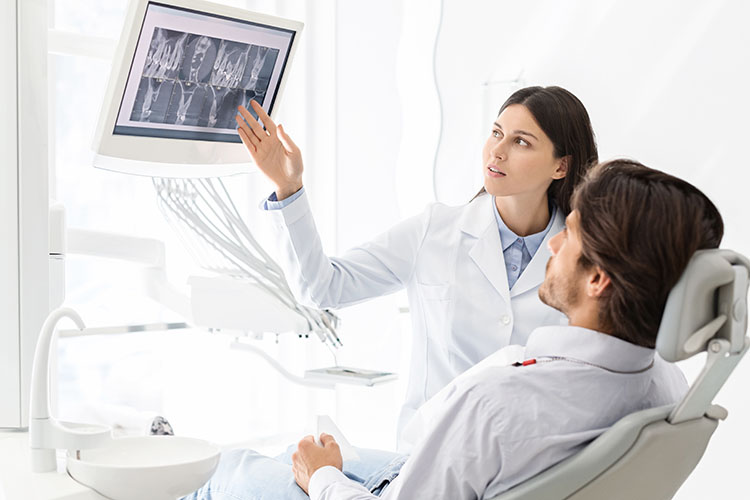 Clínica Dental Andrea Compte, tu Centro Odontológico especializado. Odontología en Alcossebre. Dentista mostrando resultados de radiografía al paciente.