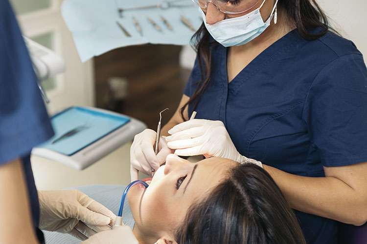 Clínica Dental Andrea Compte, tu Centro Odontológico especializado. Odontología en Cálig. Dentistas con un paciente durante una intervención dental.