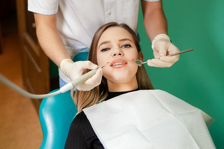 Clínica Dental Andrea Compte, tu Centro Odontológico especializado. Odontología estética en Benicarló. Dentista realizando una limpieza a una paciente.