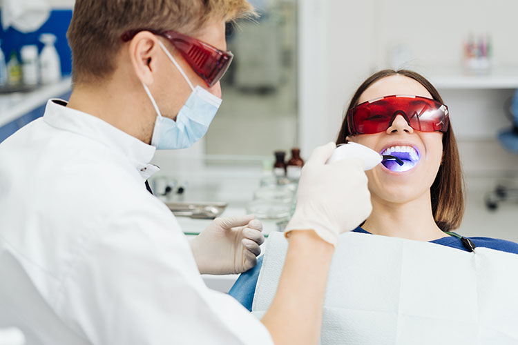 Clínica Dental Andrea Compte, tu Centro Odontológico especializado. Odontología estética en Benicarló. Dentista realizando un blanqueamiento dental a la paciente.