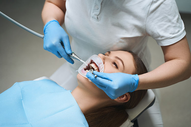 Clínica Dental Andrea Compte, tu Centro Odontológico especializado. Odontología estética en Cálig. Dentista realizando un tratamiento a la paciente.