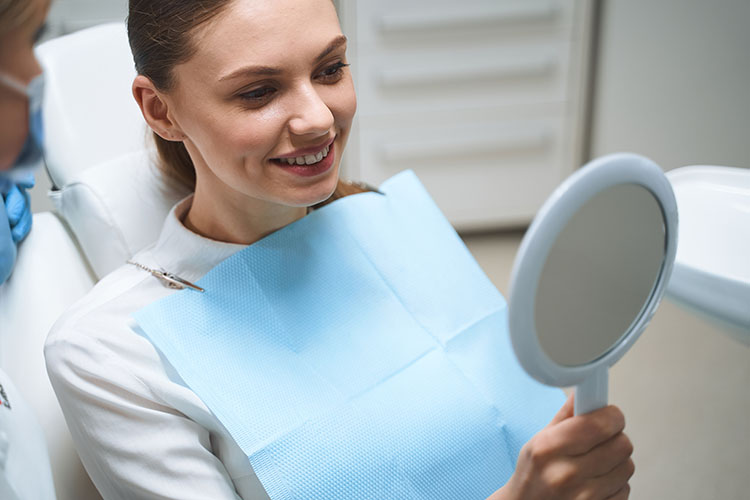 Clínica Dental Andrea Compte, tu Centro Odontológico especializado. Odontología estética en Cálig. Paciente comprobando los resultados después de su tratamiento.