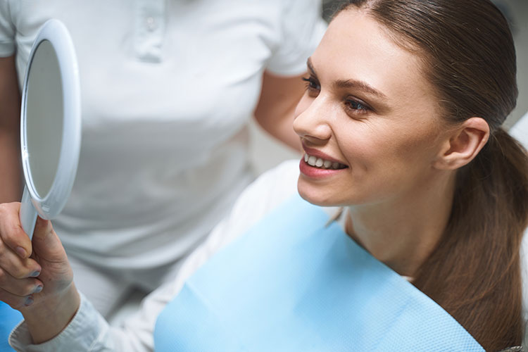 Clínica Dental Andrea Compte, tu Centro Odontológico especializado. Odontología estética en Sant Jordi. Paciente mirando los resultados de su tratamiento dental estético.
