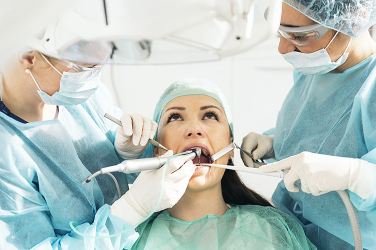 Clínica Dental Andrea Compte, tu Centro Odontológico especializado. Odontología en Vinaròs. Dentistas con un paciente durante una intervención dental.