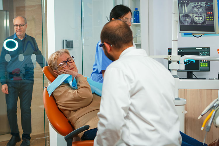 Clínica Dental Andrea Compte, tu Centro Odontológico especializado. Ortodoncia en Cálig. Mujer con dolor hablando con el ortodoncista.