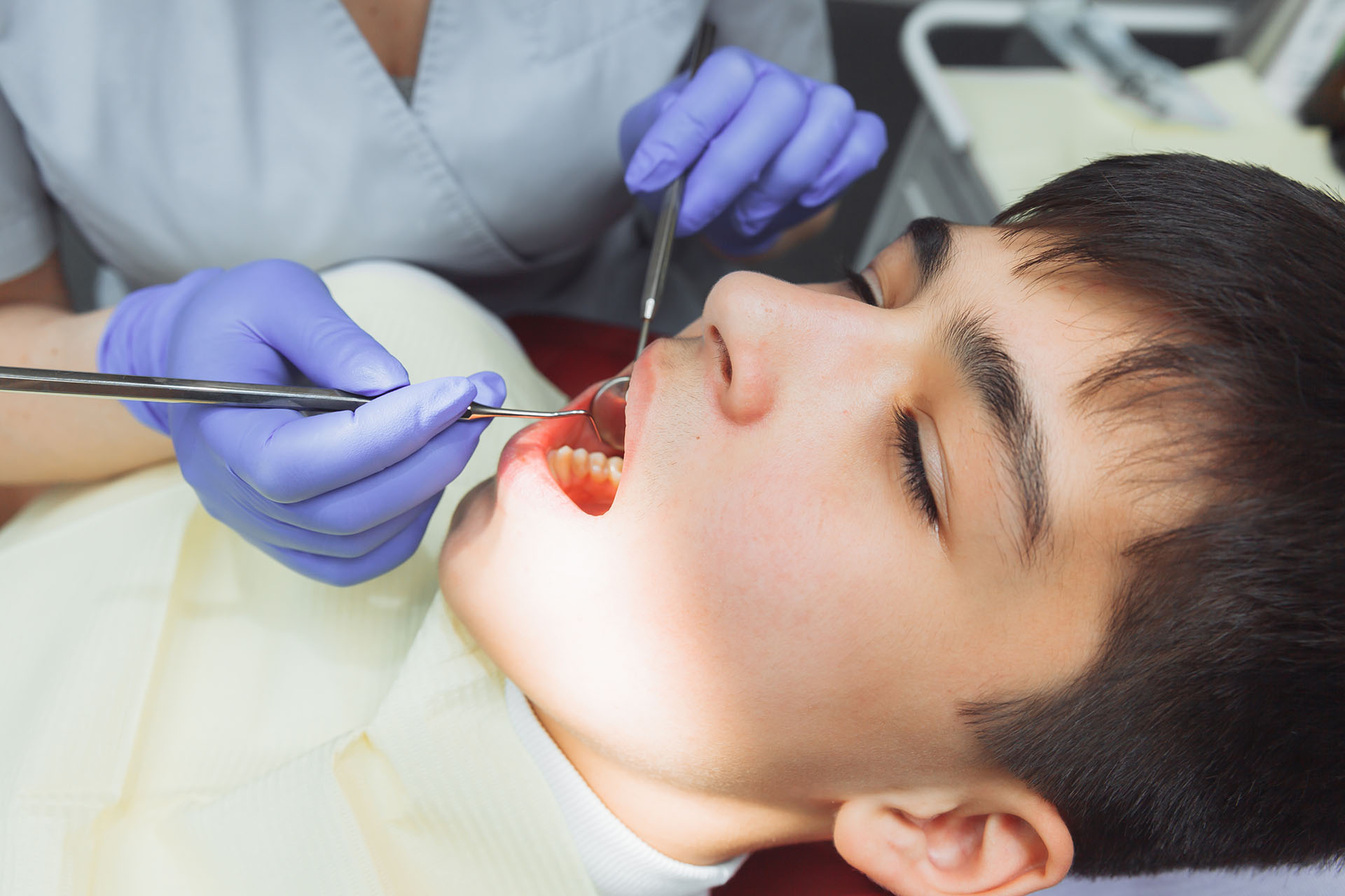 Clínica Dental Andrea Compte, tu Centro Odontológico especializado. Odontopediatría en Cálig. Odontóloga examinando a un niño.