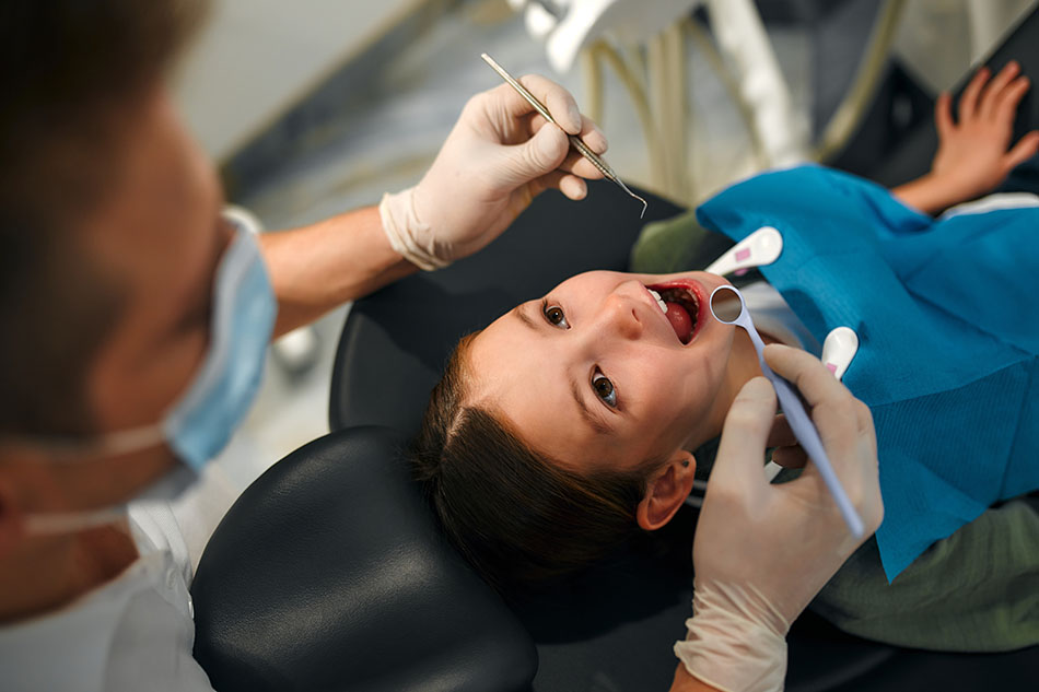 Clínica Dental Andrea Compte, tu Centro Odontológico especializado. Odontopediatría en Cervera del Maestre. Dentista pediátrico examinando a la niña pequeña.