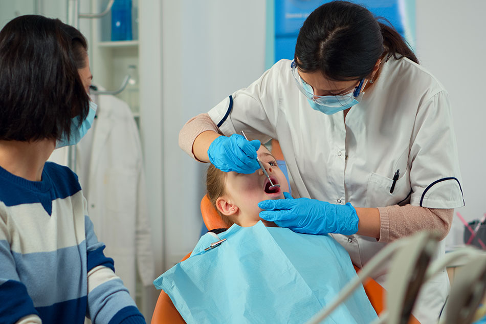 Clínica Dental Andrea Compte, tu Centro Odontológico especializado. Odontopediatría en Traiguera. Dentista pediátrico tratando los dientes de la niña.