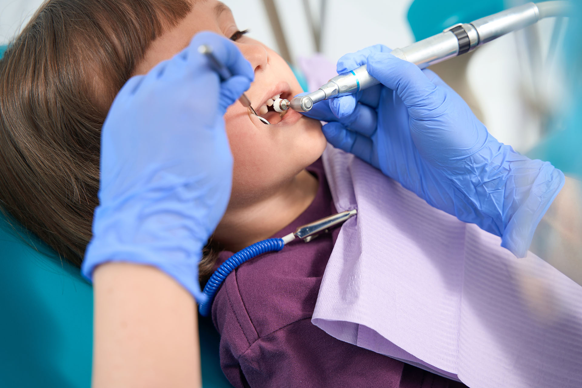 Clínica Dental Andrea Compte, tu Centro Odontológico especializado. Odontopediatría en Vinaròs. Dentista pediátrico que realiza un procedimiento de pulido de dientes en una niña.